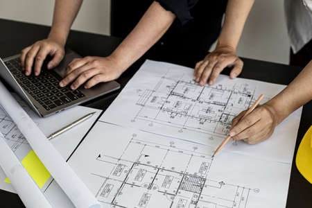 Two architects and engineers are in a meeting to discuss and inspect the house designs to meet the building and construction standards. Interior design and decoration ideas.の写真素材