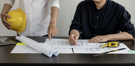 Architects and engineers are discussing house plans designed to verify accuracy and to meet design and construction standards. Interior design and decoration ideas.の写真素材