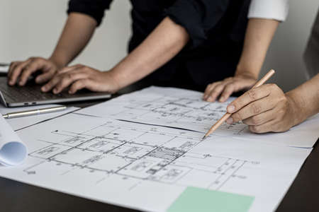 Two architects and engineers are in a meeting to discuss and inspect the house designs to meet the building and construction standards. Interior design and decoration ideas.の写真素材