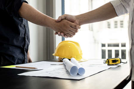 A team of architects and engineers in a big project went hand in hand after meeting on building plans. Construction and interior ideas.の写真素材