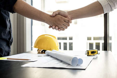 A team of architects and engineers in a big project went hand in hand after meeting on building plans. Construction and interior ideas.の写真素材