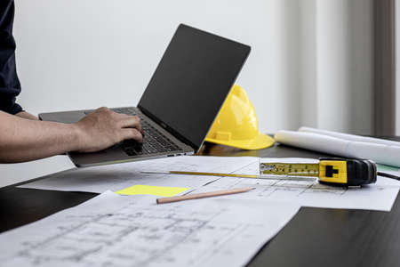 Professional home designers architects are reviewing the laptop house designs sketched in the program. Interior design and decoration ideas.の写真素材