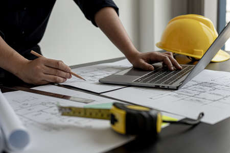Professional home designers architects are reviewing the laptop house designs sketched in the program. Interior design and decoration ideas.の写真素材