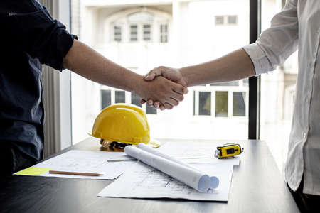 A team of architects and engineers in a big project went hand in hand after meeting on building plans. Construction and interior ideas.の写真素材