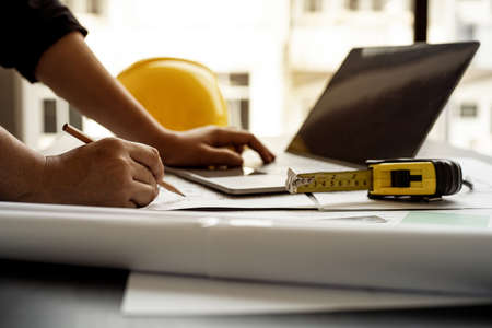 Professional home designers architects are reviewing the laptop house designs sketched in the program. Interior design and decoration ideas.の写真素材
