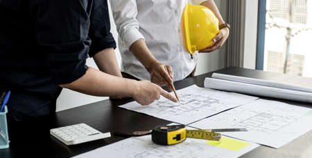 Two architects and engineers are in a meeting to discuss house designs according to building and construction standards before presenting them to clients. Interior design and decoration ideas.の写真素材