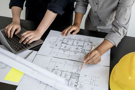 Two architects and engineers are in a meeting to discuss and inspect the house designs to meet the building and construction standards. Interior design and decoration ideas.の写真素材