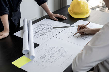 The architects and engineers were in a meeting to discuss the draft house plan designed after it was presented to the client. A partial design revision was requested. Interior design and decoration ideas.の写真素材