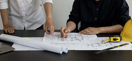 Architects and engineers are discussing house plans designed to verify accuracy and to meet design and construction standards. Interior design and decoration ideas.の写真素材