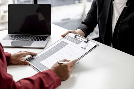 The job applicant is submitting a resume to the manager for a job interview. The concept of a job interview in a position that matches the candidate's qualifications and abilities.の写真素材