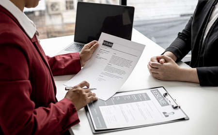The manager is interviewing job applicants and reading the candidate's personal information on the resume. The idea of recruiting to recruit people to work in the missing position.の写真素材