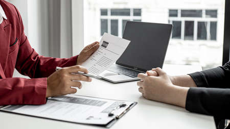 The manager is interviewing job applicants and reading the candidate's personal information on the resume. The idea of recruiting to recruit people to work in the missing position.の写真素材