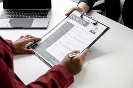 The job applicant is submitting a resume to the manager for a job interview. The concept of a job interview in a position that matches the candidate's qualifications and abilities.の写真素材