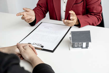 An employee of the rental company was explaining to tenants in detail the rental agreement before agreeing to sign the rental agreement with the company.の写真素材