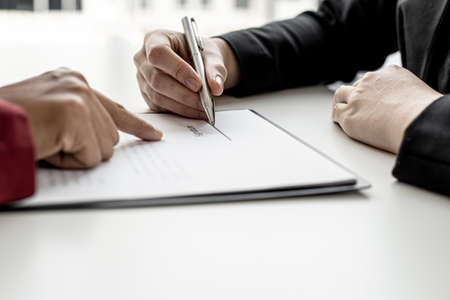 The tenant is signing a lease agreement with the landlord after viewing the home and discussing the rental agreement details. Real estate rental ideas.の写真素材