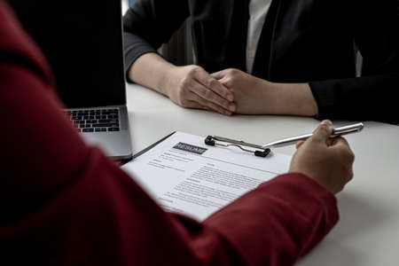 The HR department is reviewing the applicant's resume before giving them an interview with the department manager. The concept of recruiting people to work in the company.の写真素材