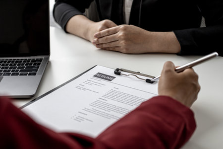 The HR department is reviewing the applicant's resume before giving them an interview with the department manager. The concept of recruiting people to work in the company.の写真素材