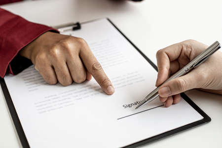 The tenant is signing a lease agreement with the landlord after viewing the home and discussing the rental agreement details. Real estate rental ideas.の写真素材