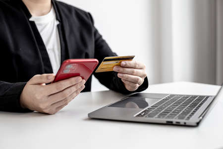 Business women are filling out credit card information into an online shopping app on a smartphone. Concept of payment for products in a smartphone app.の写真素材