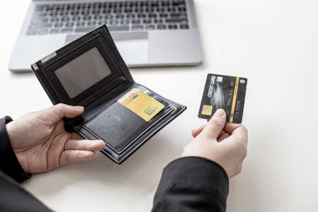 The businesswoman opened her wallet and picked up a credit card to pay for the food she had arranged for a customer to talk to. The idea of paying for food using a credit card.の写真素材