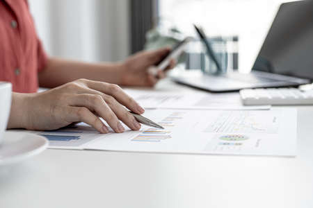 A business finance woman is reviewing a company's financial documents prepared by the Finance...