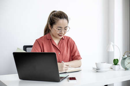 A female company worker sitting in her home office, her company has measures to work from home to prevent the spread of the COVID-19 virus. The idea of working from home.の写真素材