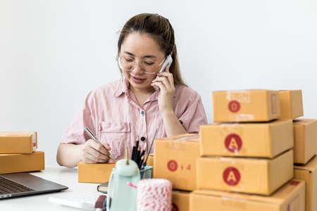 Employees are writing customer shipments to order products through online websites and deliver products through private transportation services. Product sales concepts online.の写真素材