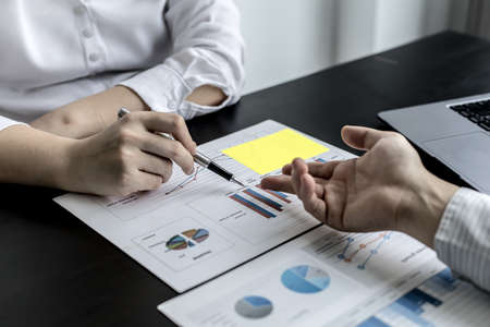 Two businessmen pointed to the material for the meeting, working together to plan to develop and solve common business problems. Concept of business management for growth and quality.の写真素材