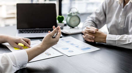 Two businessmen are talking in the office, they are discussing business partnerships to find ways to develop the business and solve problems. Concept of business management for growth and quality.の写真素材