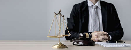 A male lawyer sits in his office, on a table with a small hammer to beat the judge's desk in court....