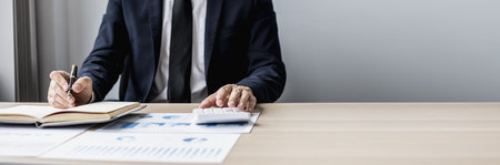 Businessman sits in a private office at his company and is reviewing company financial documents, senior management checking financial information for accuracy. Financial management. copy spaceの写真素材