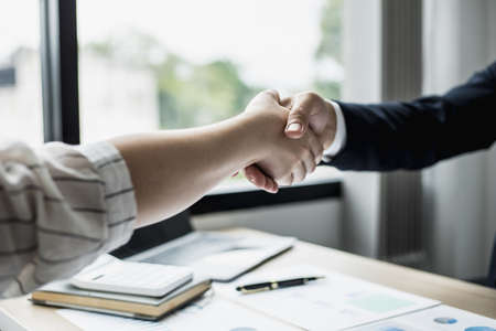 Two businessmen shake hands, they are startup friends together, business partners shake hands after brainstorming and planning a startup company. The management concept of a startup company.の写真素材