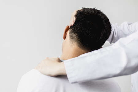 A professional physiotherapist is stretching the neck muscles of a patient undergoing therapy, most patients are office workers who sit for long periods of time causing pain. Physical therapy concept.の写真素材