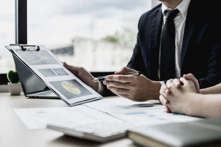 Two businessmen are meeting together on the topic of monthly finance, financial documents prepared by the finance department. Concept of financial management according to company policy.の写真素材