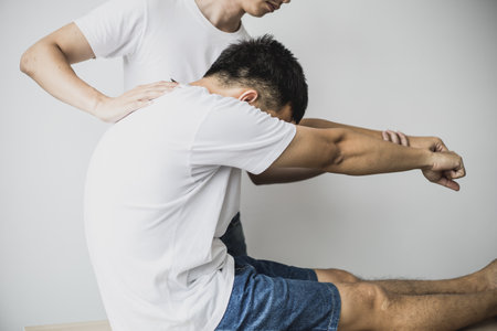A professional physiotherapist is stretching the back muscles for patients who undergo therapy, most...