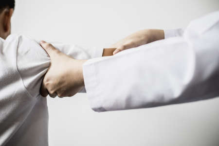 A professional physiotherapist is doing stretching for a patient, the patient has muscle dysfunction due to hard work, most often an office worker who has problems sitting for long periods of time.の写真素材