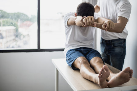 A professional physiotherapist is stretching the back muscles for patients who undergo therapy, most of them are office workers who sit for a long time and cause pain. office syndromeの写真素材