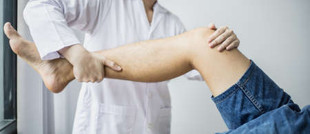 A professional physiotherapist is stretching the patient's legs, the patient has muscle dysfunction...