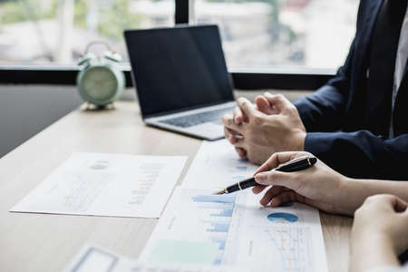 Two businessmen are reviewing monthly sales documents for analysis and marketing plans for more sales growth, they are the founders of young companies co-founding startups. Sales management concept.の写真素材