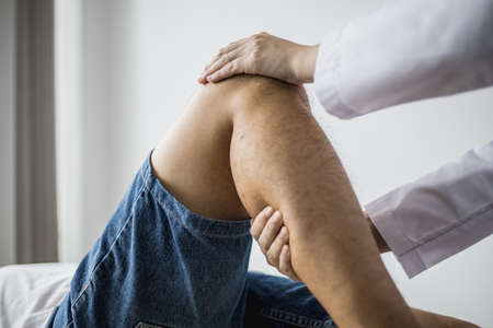 A professional physiotherapist is stretching the patient's legs, the patient has muscle dysfunction...