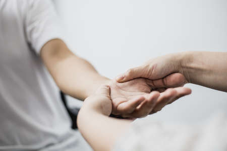 A professional physiotherapist is doing a massage to loosen the hand muscles of patients undergoing therapy, most patients are office workers who sit for long periods of time causing pain.の写真素材
