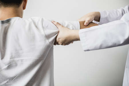 A professional physiotherapist is doing stretching for a patient, the patient has muscle dysfunction due to hard work, most often an office worker who has problems sitting for long periods of time.の写真素材