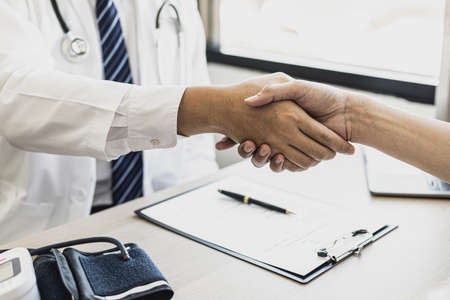 The doctor and patient shake hands after the examination and the results have been reported. concept of disease diagnosis and encouragement in the treatment of serious diseases.の写真素材