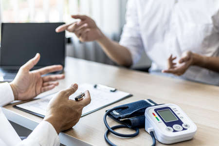 The doctor shows a document informing the results of the examination, the doctor explains the results of the tests found and treatment guidelines. Concept of examination and treatment of disease.の写真素材