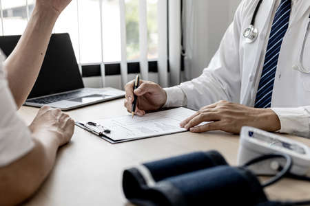 The doctor shows a document informing the results of the examination, the doctor explains the results of the tests found and treatment guidelines. Concept of examination and treatment of disease.の写真素材