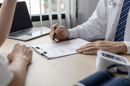 The doctor shows a document informing the results of the examination, the doctor explains the results of the tests found and treatment guidelines. Concept of examination and treatment of disease.の写真素材