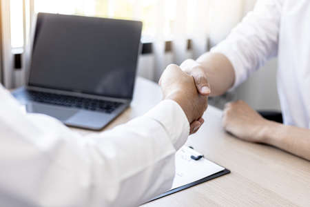 The doctor and patient shake hands after the examination and the results have been reported. concept of disease diagnosis and encouragement in the treatment of serious diseases.の写真素材