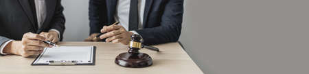Two male lawyers are consulting together to draft a contract acknowledgment for their clients, they form partnerships to open a law firm. The idea of opening a law firm to accept the lawsuit.の写真素材