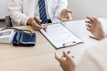 Doctors and patients are talking in the examination room of a private hospital, they are discussing symptoms and treatment of detected diseases. Concept of examination and treatment of disease.の写真素材