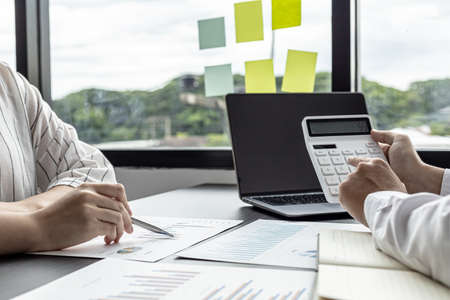 Two businessmen are meeting together on corporate finance, they are business partners who open a company together, they are brainstorming and analyzing ways to manage money more effectively.の写真素材